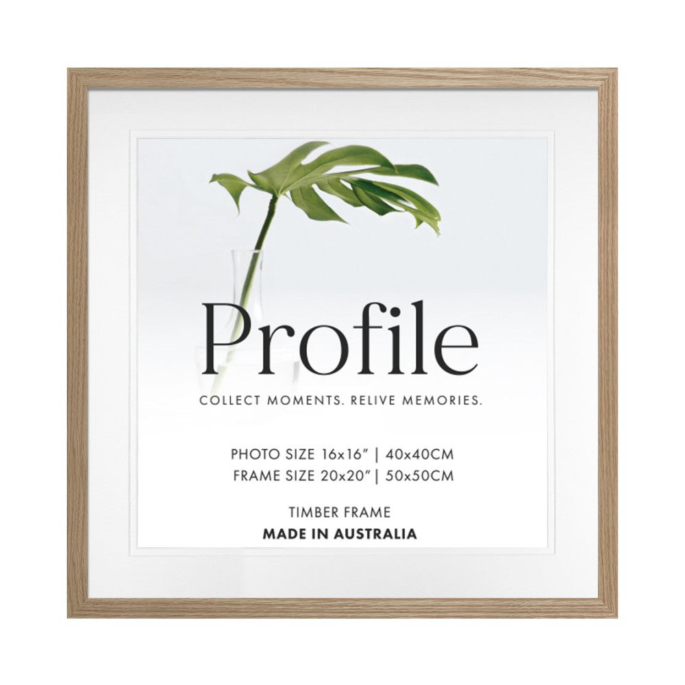Front view of a natural oak timber picture frame with white matting, displaying a green plant stem and "Profile" branding text.