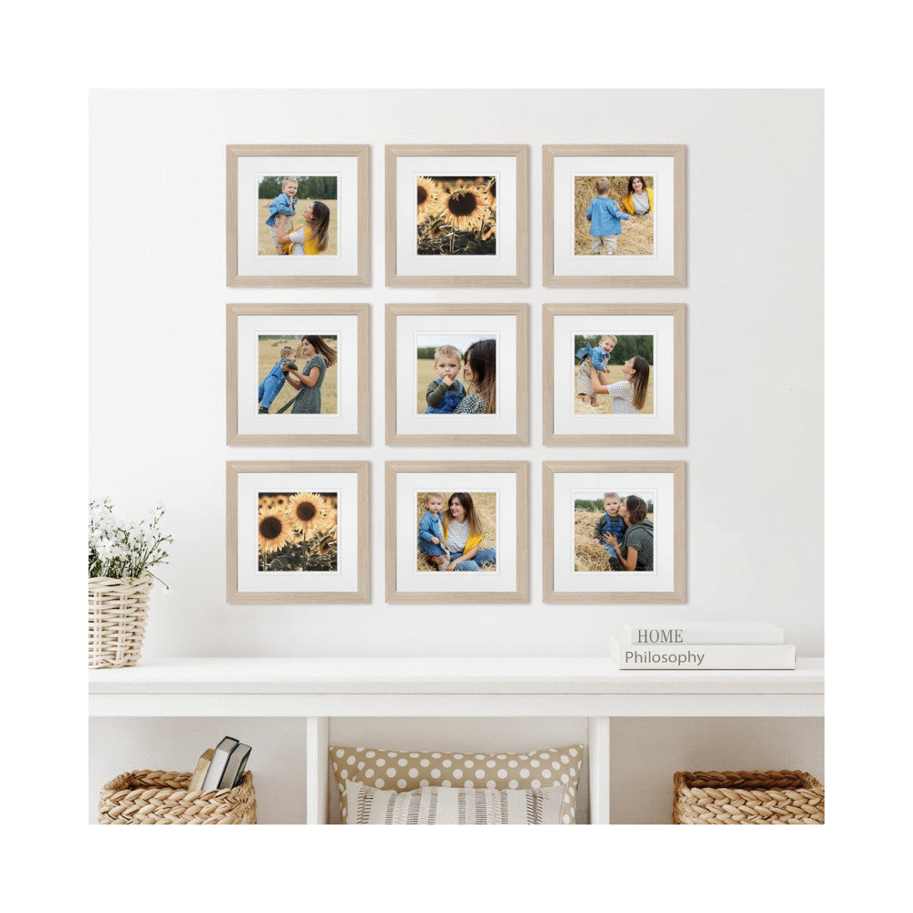 Nine framed photos arranged in a 3x3 grid on a white wall, displaying family portraits and nature images in light wood frames with white mats.