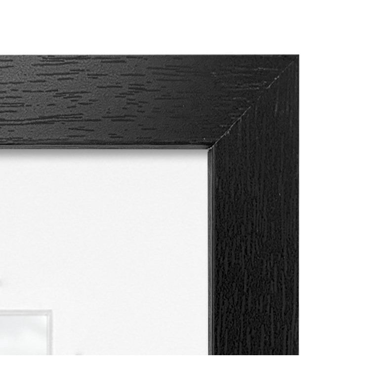 Close-up detail of black wooden picture frame corner showing wood grain texture and beveled edge design