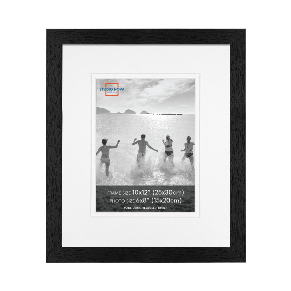 Black wooden picture frame displaying a black and white beach photo of four people running into the ocean, with white matting.