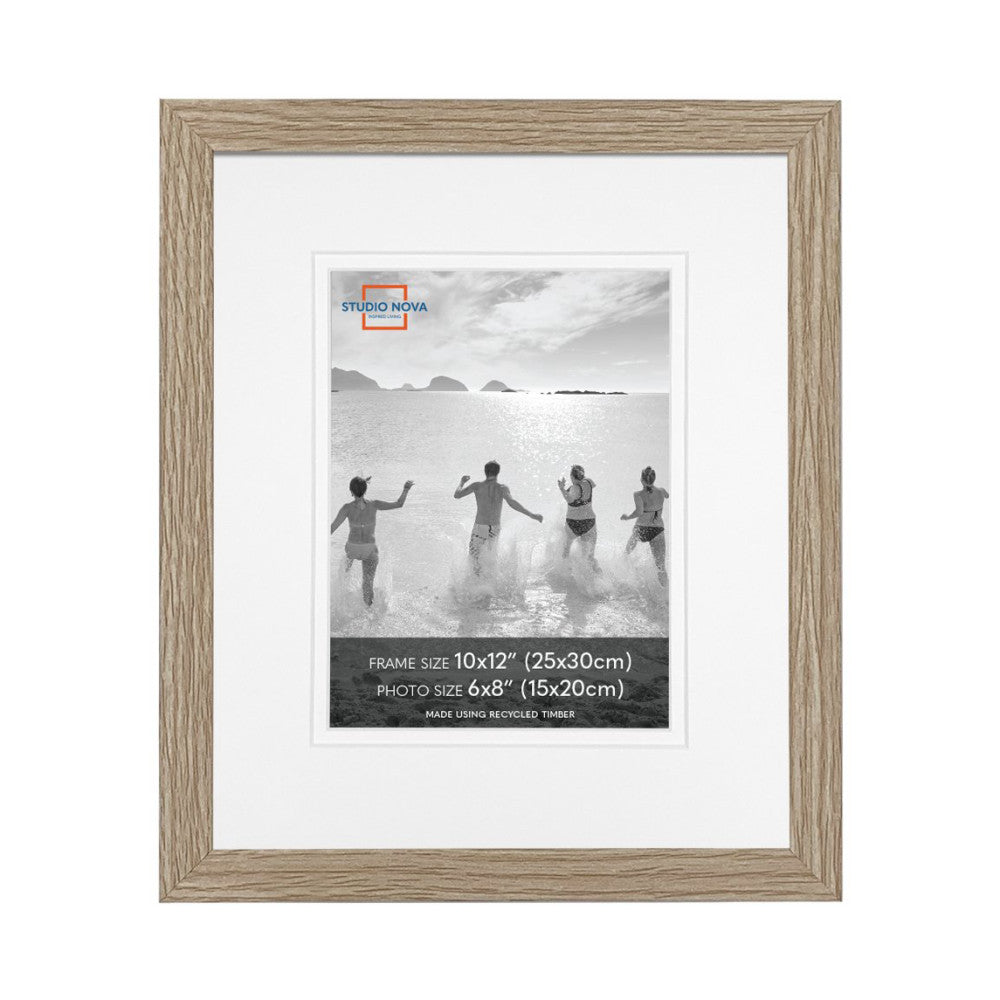 Front view of a single wooden picture frame with white mat containing a black and white beach photo of four people running into the ocean.