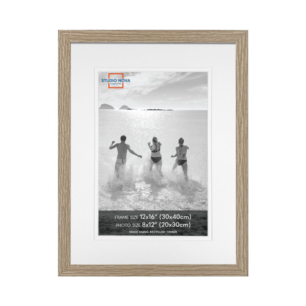 Front view of a single wood-framed photo display showing three people running into the ocean in black and white.
