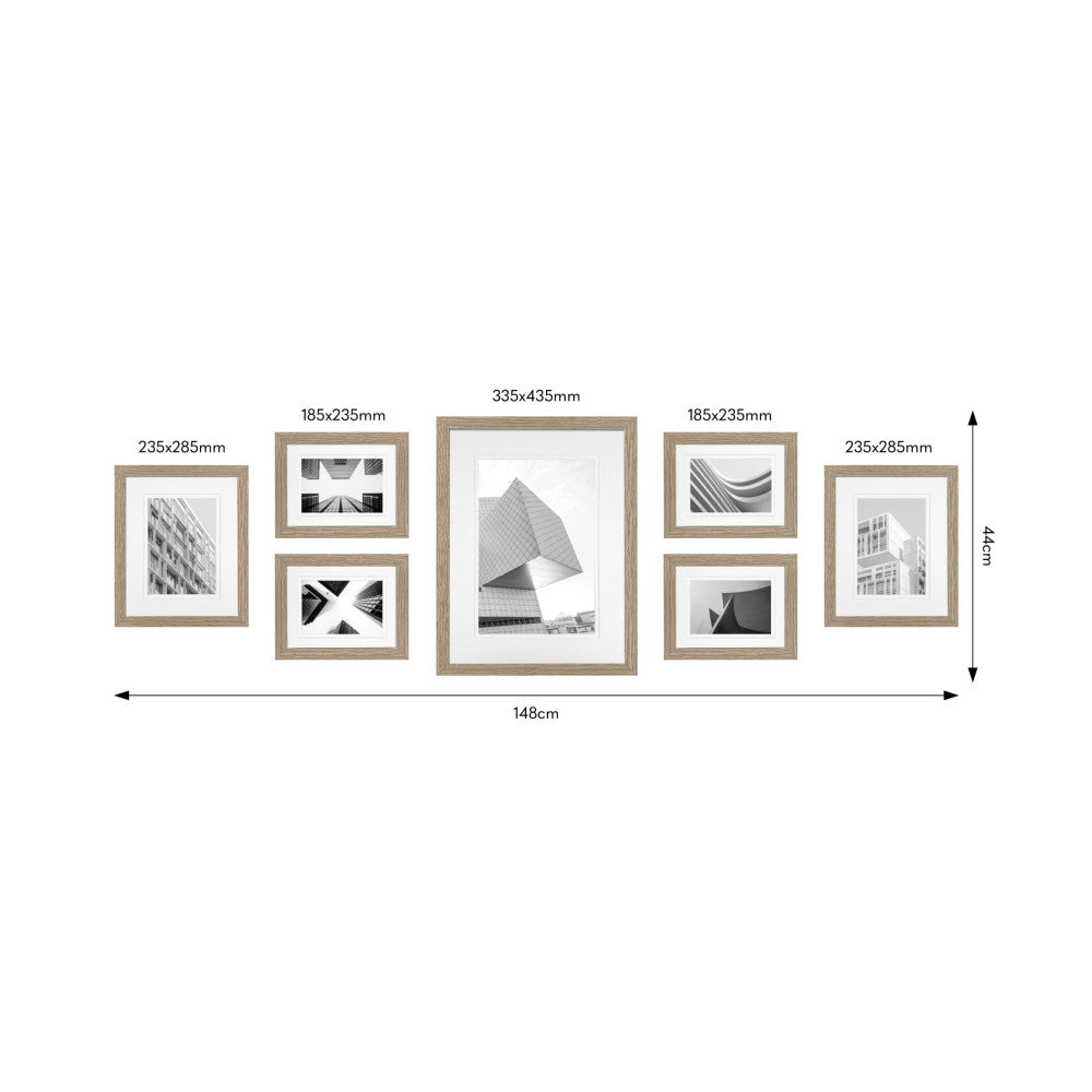 Front view of seven wooden frames arranged in a gallery wall layout with architectural photography, showing dimensions and spacing measurements.