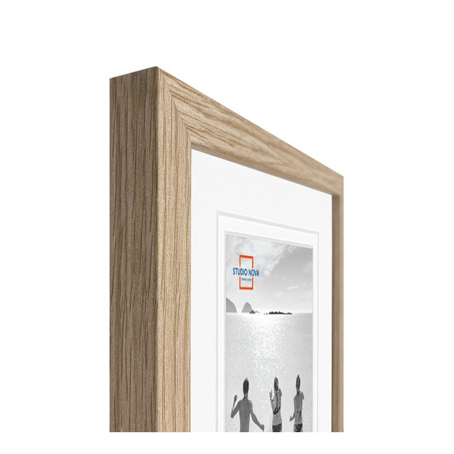 Close-up detail of a natural wood frame corner showing the beveled edge and light wood grain texture with a matted photograph visible inside.