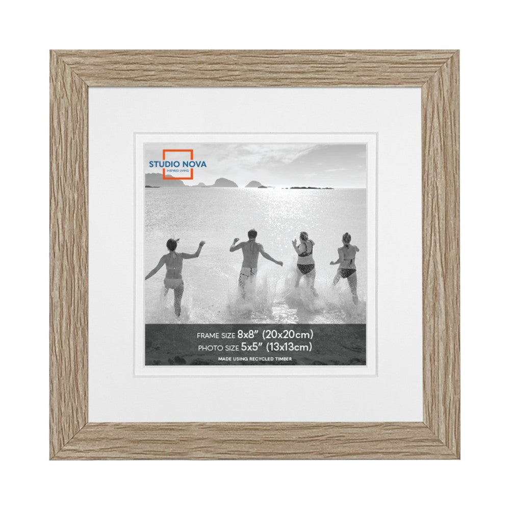 Single wooden frame with light wood finish displaying black and white photo of children running into ocean, matted with white border.