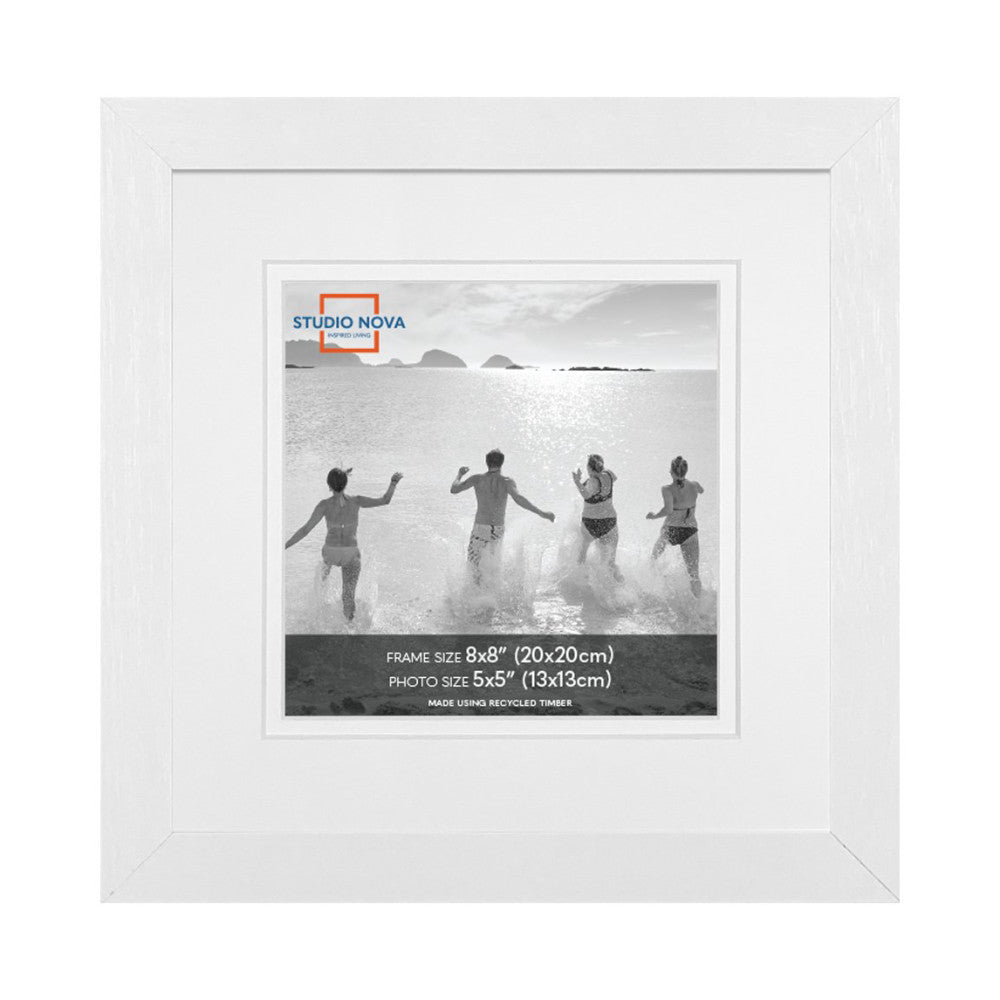 White wooden picture frame displaying a black and white beach photo of five people running into the ocean, shown from the front.