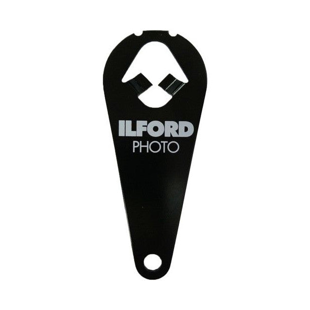 Black plastic film cassette tool with Ilford Photo branding, shown from front view with diamond-shaped cutout and circular hole at bottom.