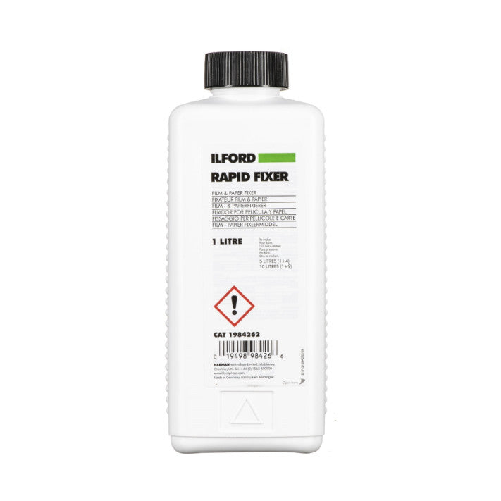 White plastic bottle of Ilford Rapid Fixer photographed from front, showing label with green stripe, hazard symbol, and product information.