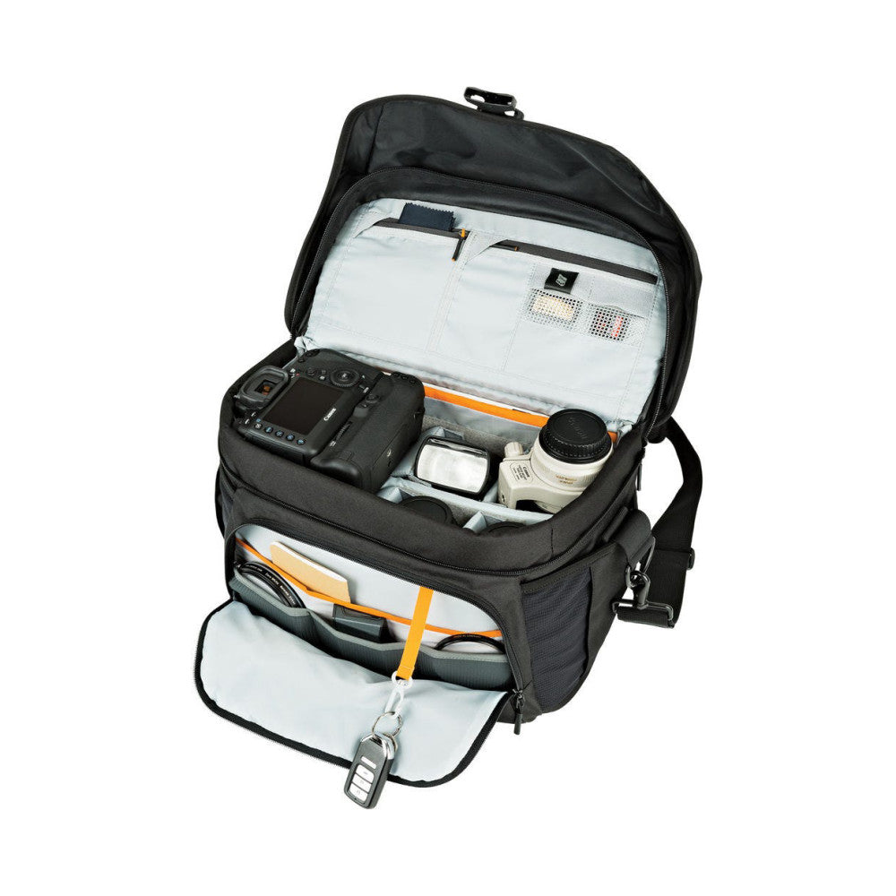 Open overhead view of black camera backpack showing organized interior compartments with camera equipment, lenses, and accessories neatly arranged.