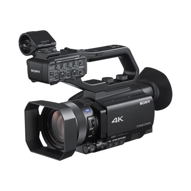 Sony HXR-NX80 4K camcorder shown at three-quarter angle displaying lens, control panel, and shoulder support against white background.